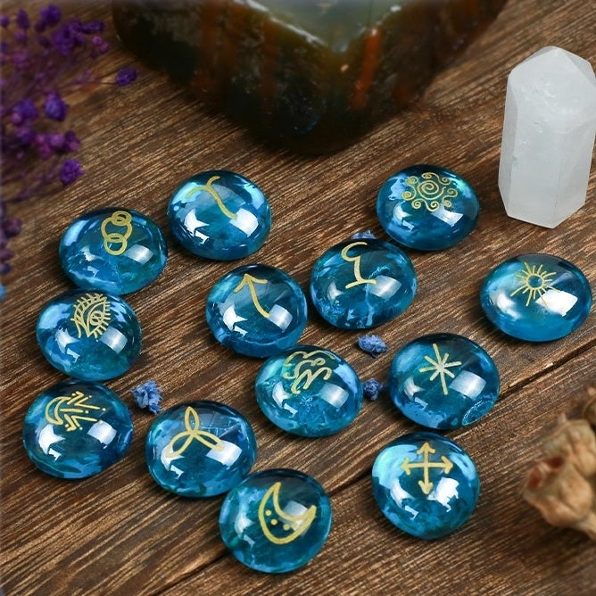 Blue rune stones with gold symbols on a wooden surface with crystals and flowers.