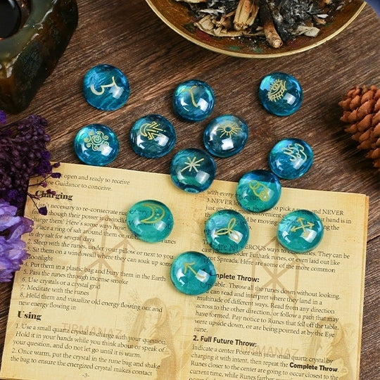 Blue crystal witch stonr with symbols on a wooden surface with a book and dried herbs.