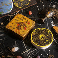 Tarot card box and Round Gold Foil cards on a black astrological patterned surface