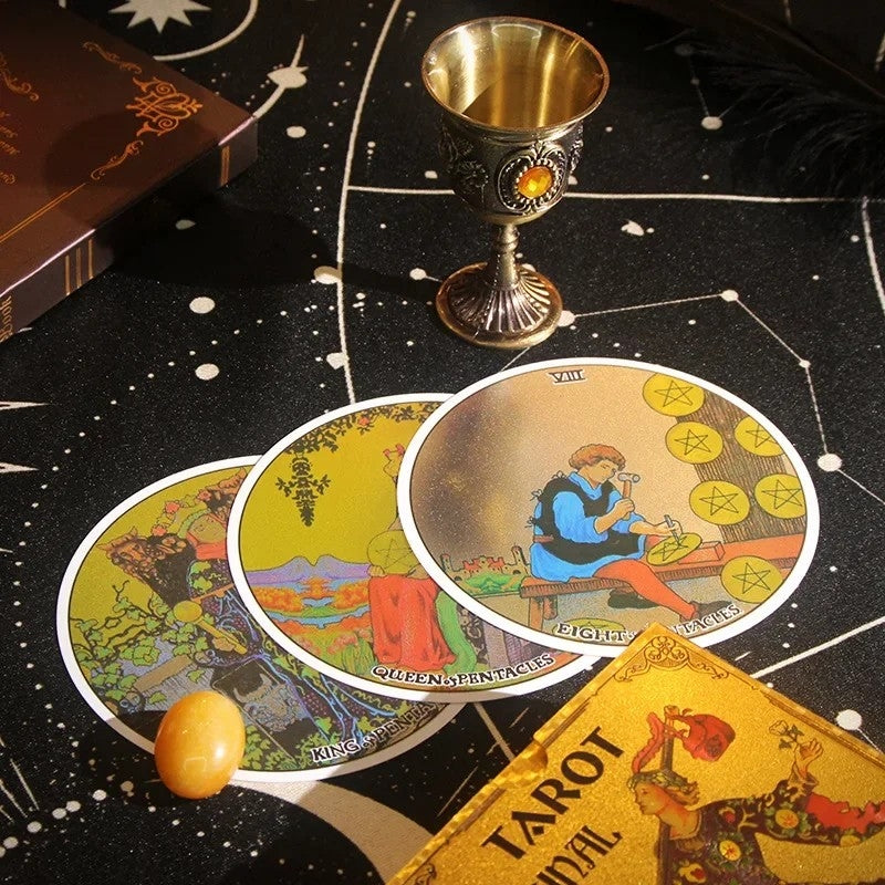 Circular Gold Foil Tarot cards and a chalice on a black astrological table