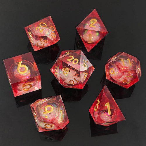 Set of red resin liquid core dice with gold foil numbers on a black background