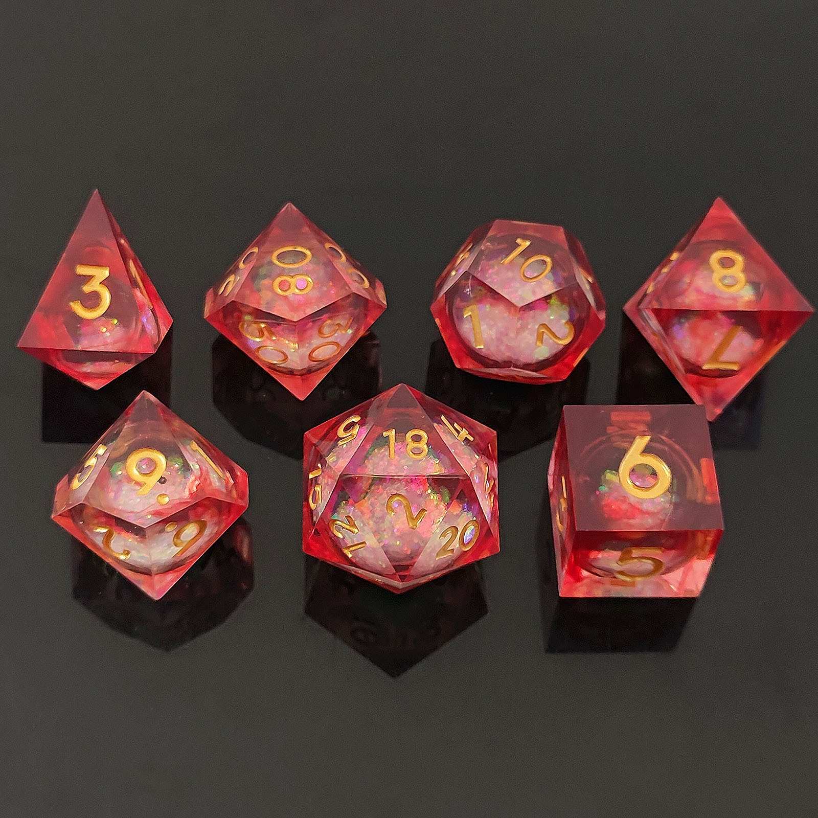 Set of red resin liquid core dice with gold numbers on a black background