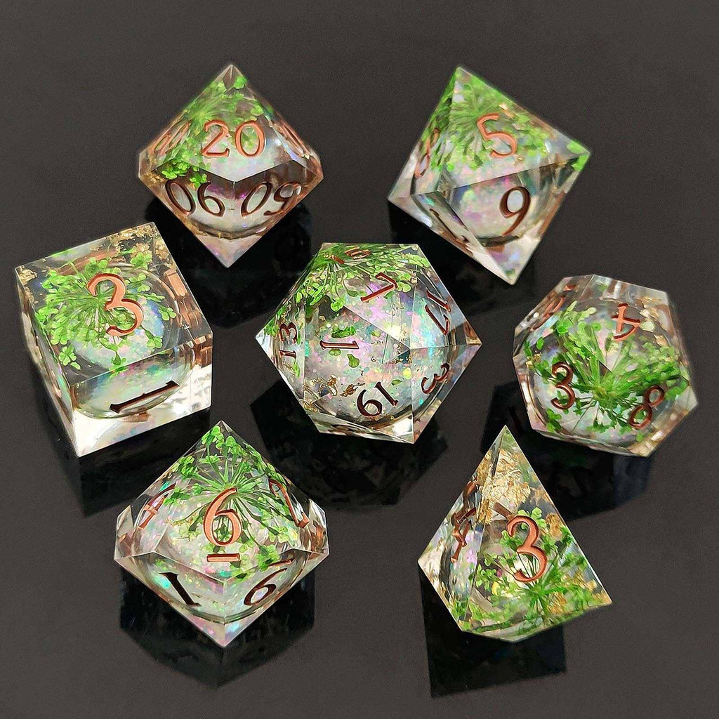 Set of seven transparent botanical resin liquid sand core dice with green and brown numbers on a dark background