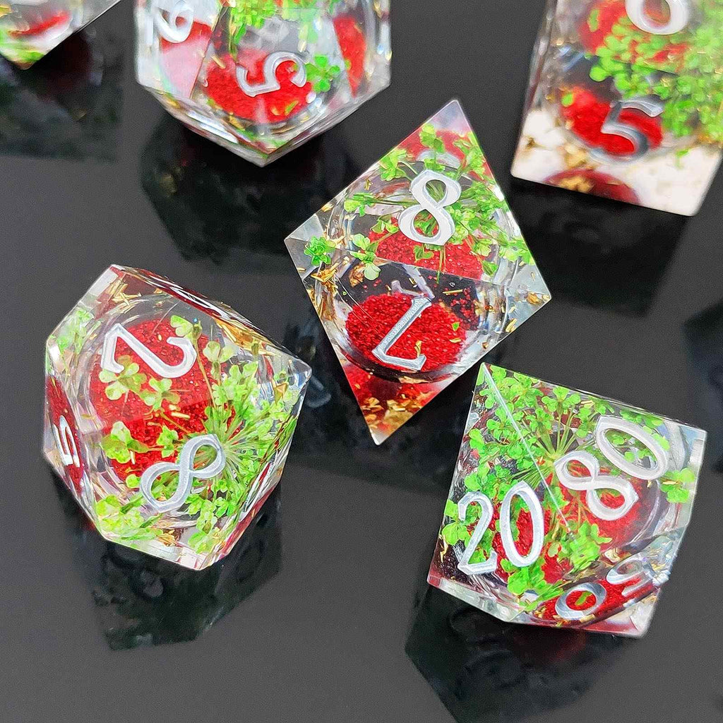 Set of polyhedral dice with red, green, and white numbers on a reflective black surface