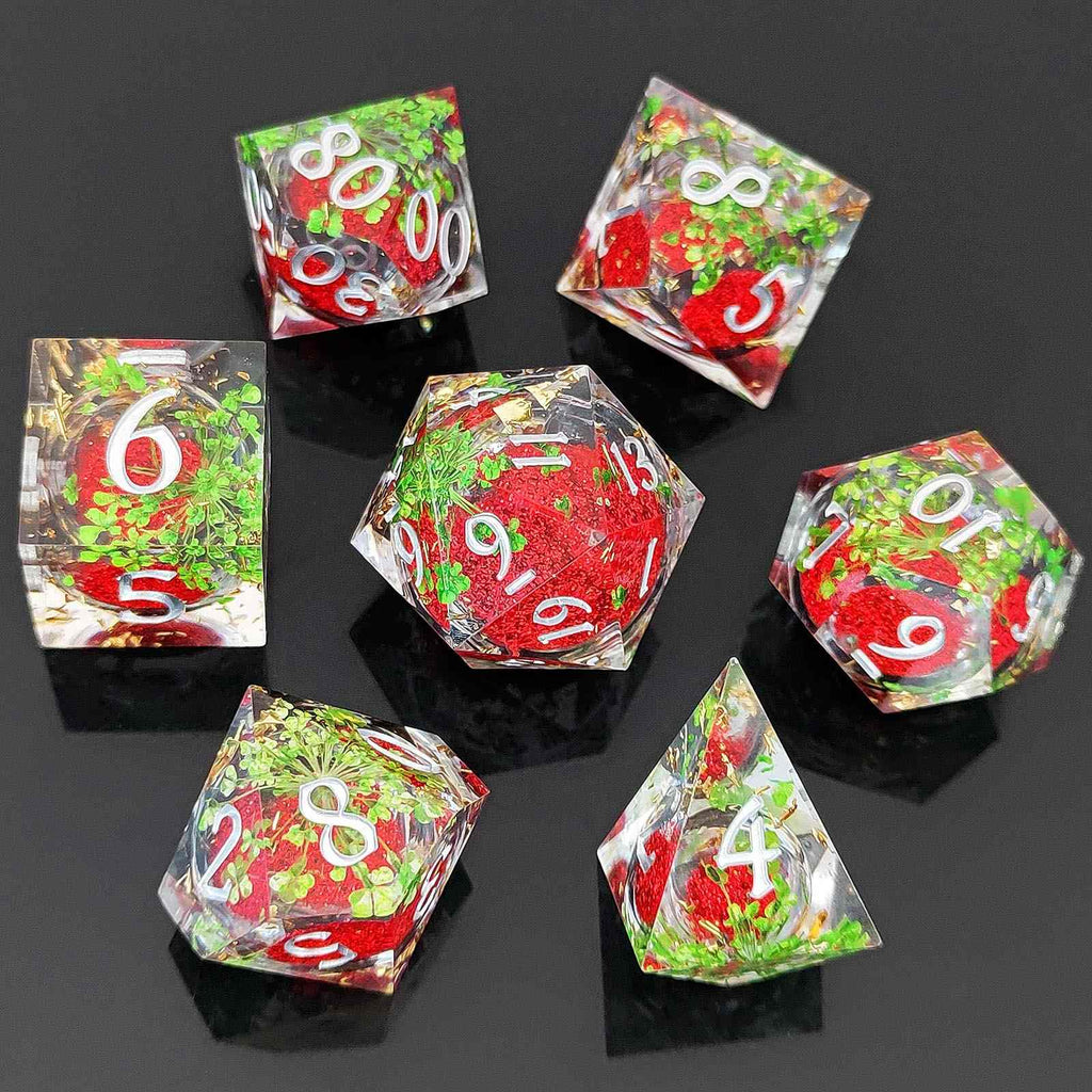 Set of colorful botanical resin liquid sand core dice with red, green, and clear faces on a black background