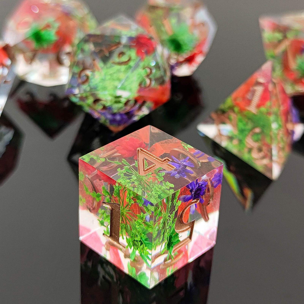 Colorful crystal botanical resin dice with embedded plants on a reflective surface