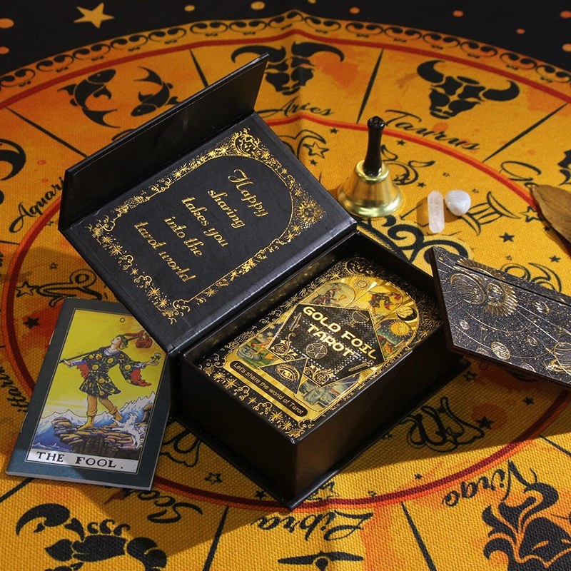 Black tarot card box with gold text on a tarot card surface