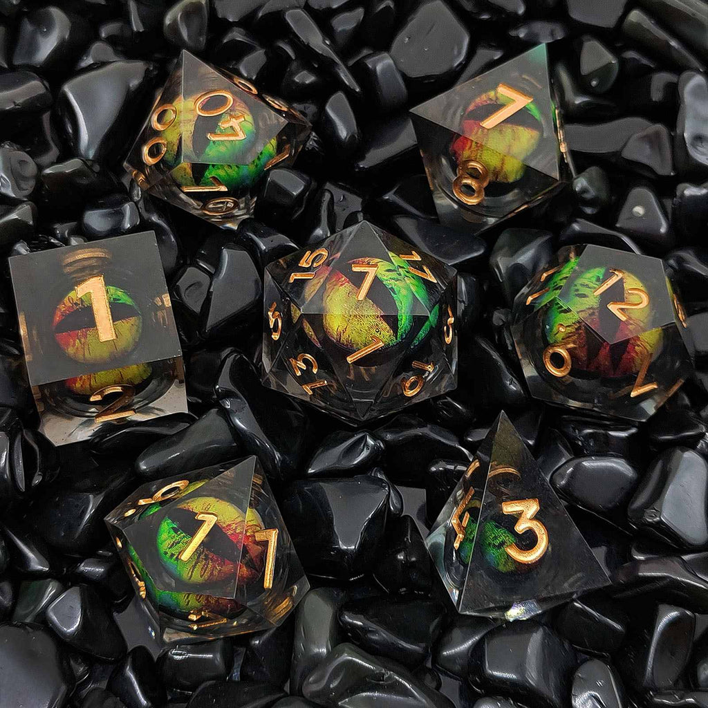 Set of black and gold polyhedral dice with colorful numbers on a black stone background