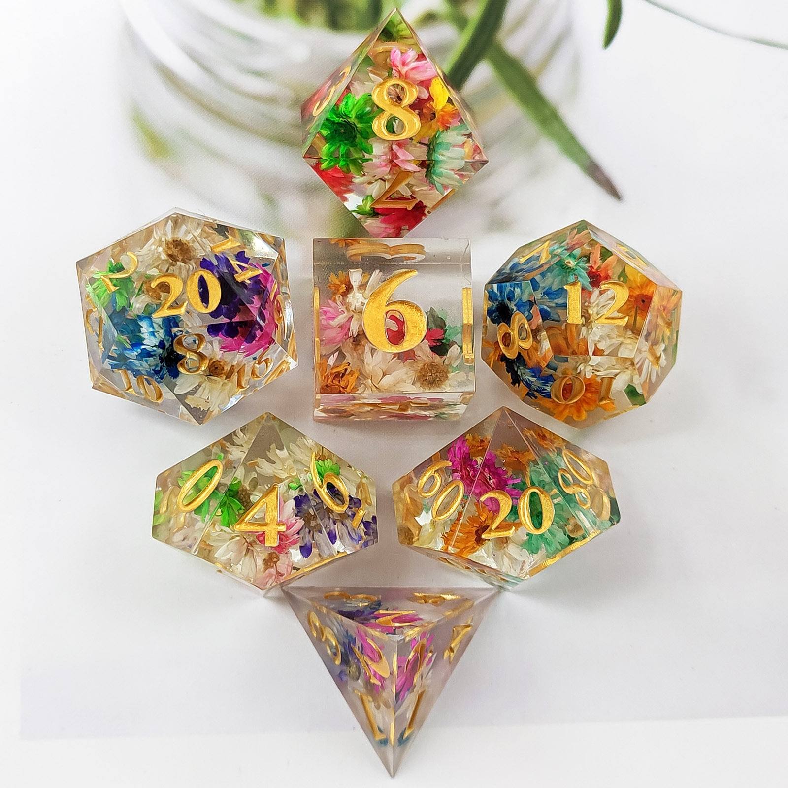 Set of colorful Sharp Edge Polyhedral resin dice with floral and natural elements on a white background