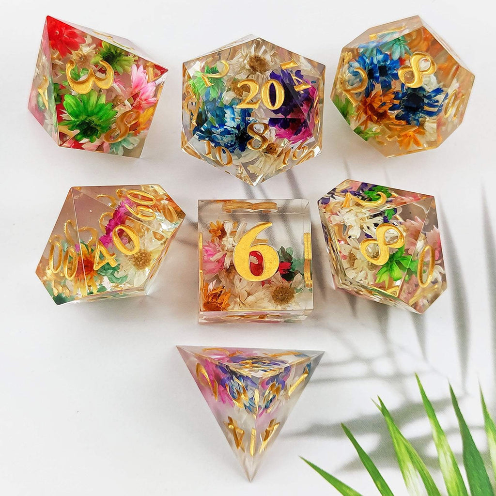 Sharp Edge Polyhedral resin dice with floral and gold number designs on a white background