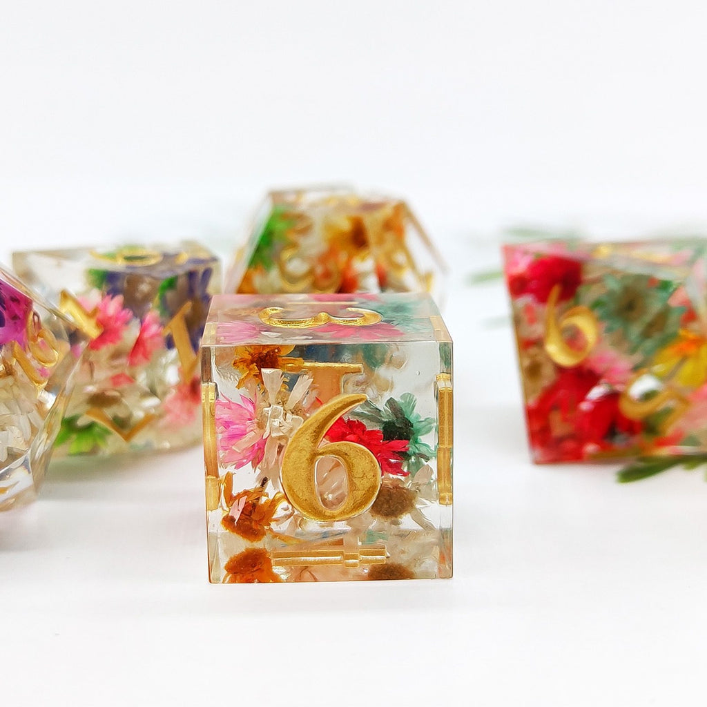 Clear Sharp Edge Polyhedral resin dice with floral and gold number 6 design on a white background