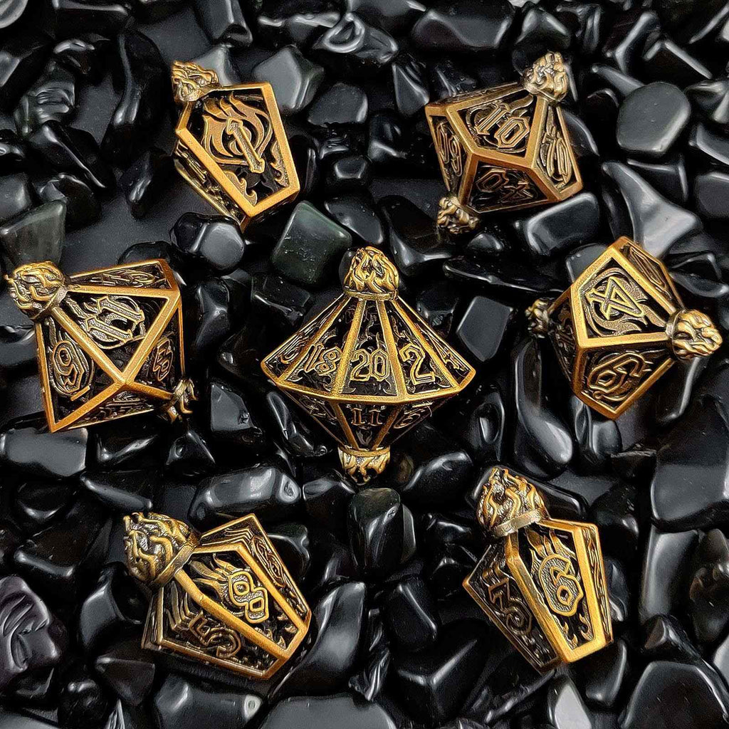 Gold lantern shaped metal hollow polyhedral dice set on black stone surface