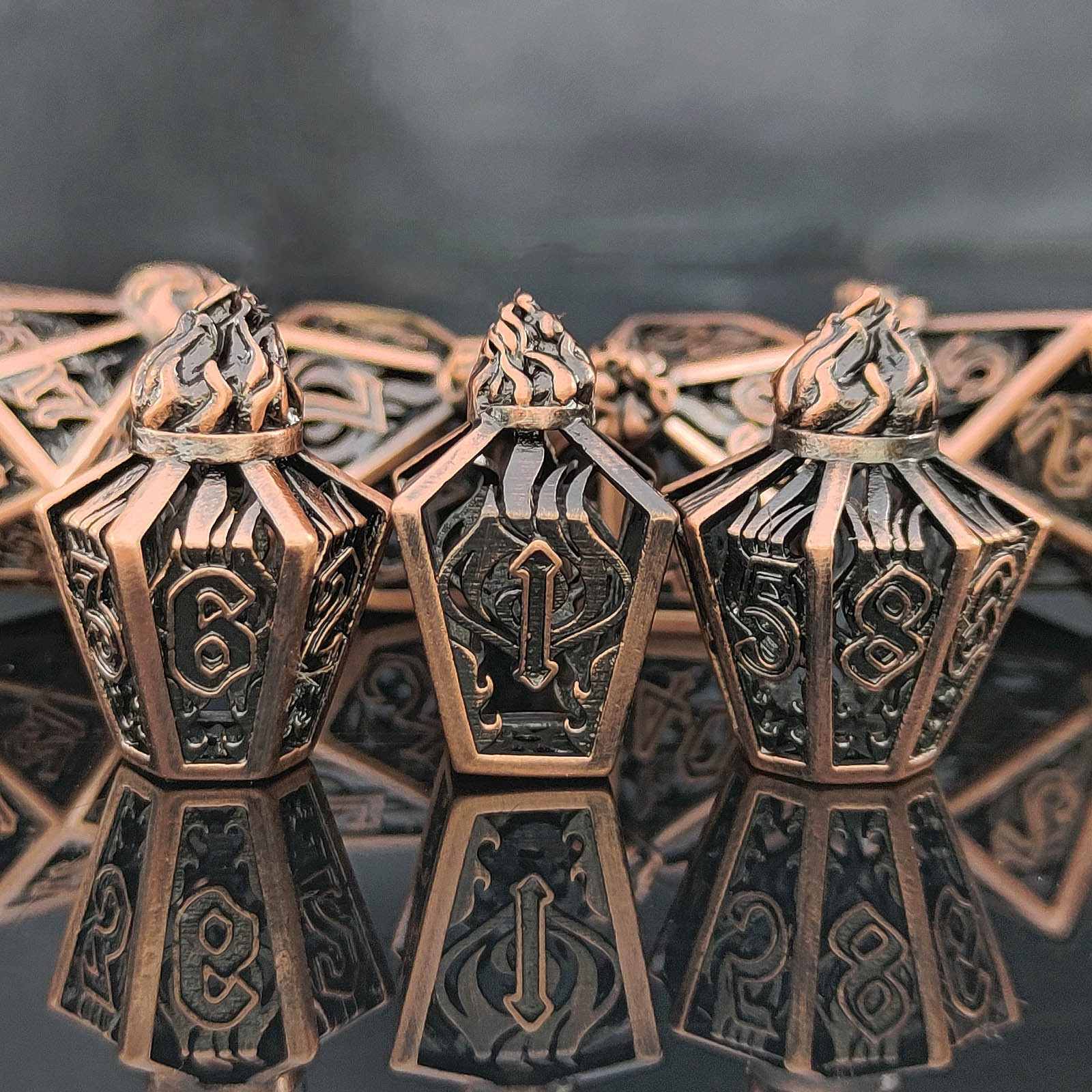 Bronze hollow polyhedral dice set on a reflective surface with a dark background