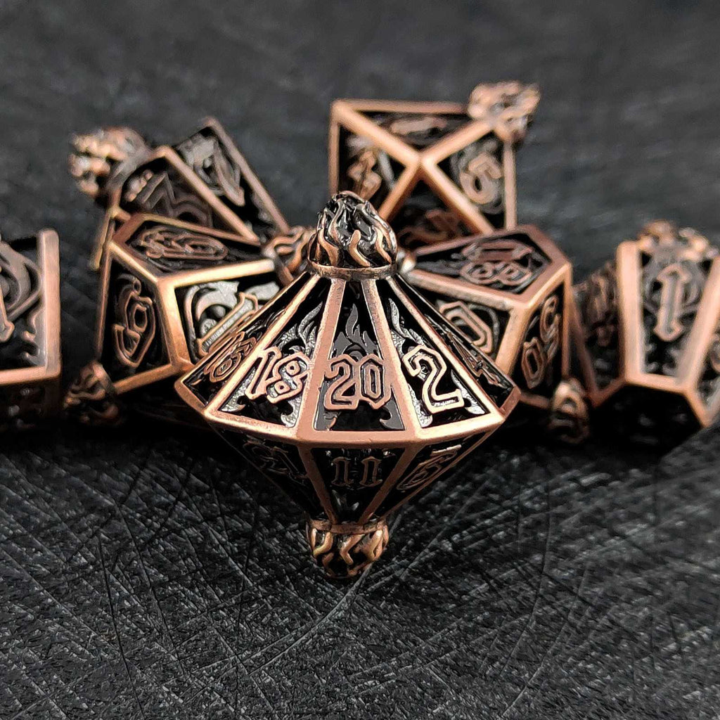 Set of bronze polyhedral hollow dice on a dark textured surface