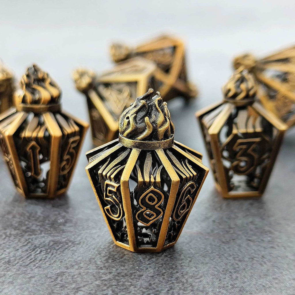 lantern shaped metal hollow bronze dice with numbers on a gray surface