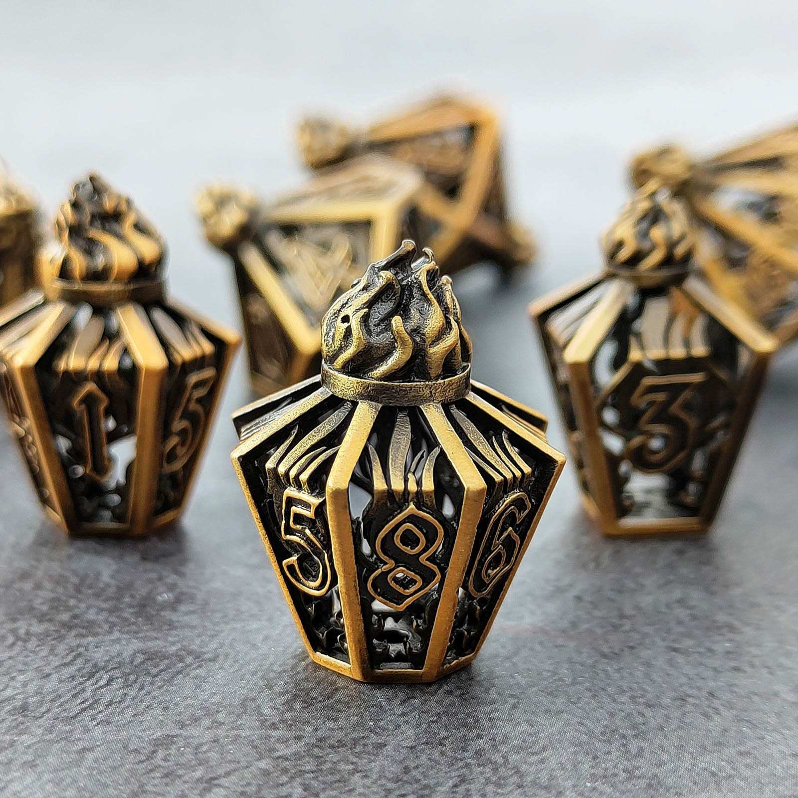 lantern shaped metal hollow bronze dice with numbers on a gray surface