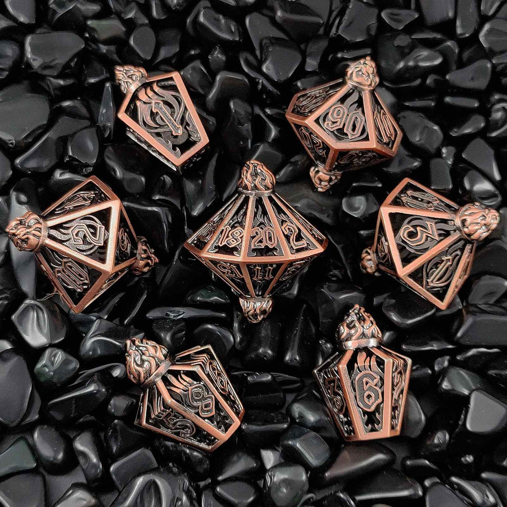 Set of bronze polyhedral hollow dnd dice on black pebbles