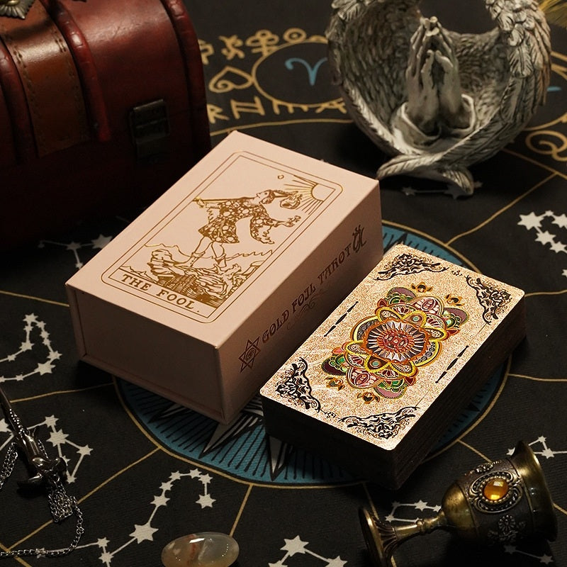 Gold Foil Tarot Card Deck of cards with intricate designs on a mystical-themed table.