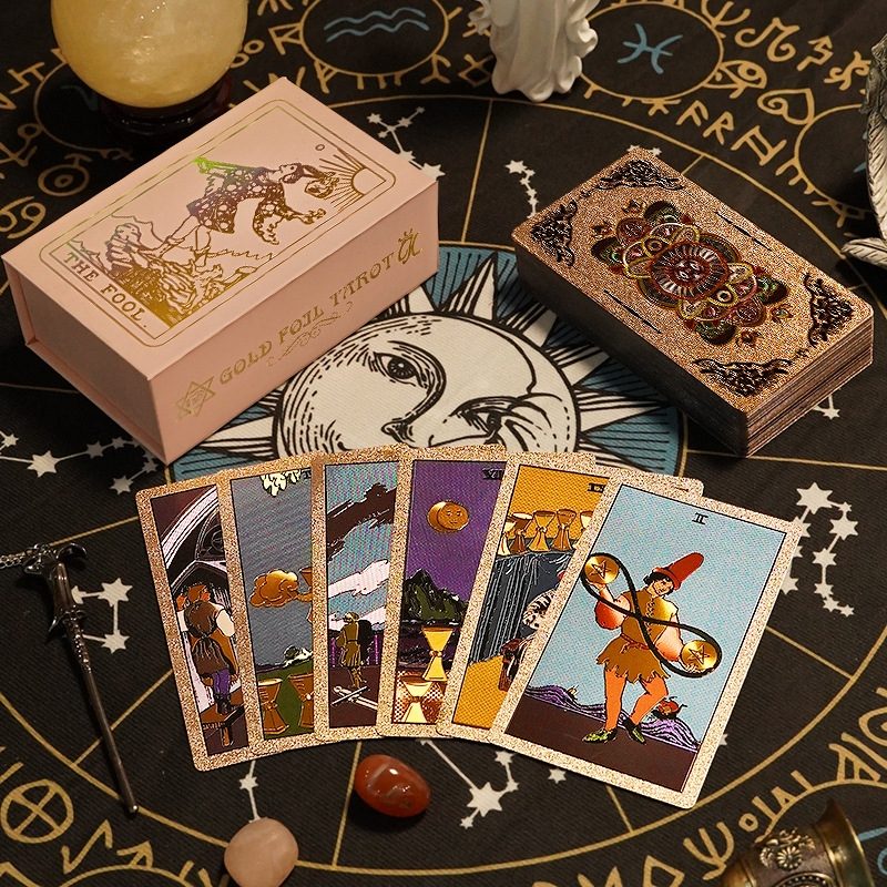 Collection of Gold Foil Tarot Card Deck on a black astrological wheel with decorative elements.