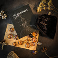 Witch runes set with book and amber class stones on a dark surface