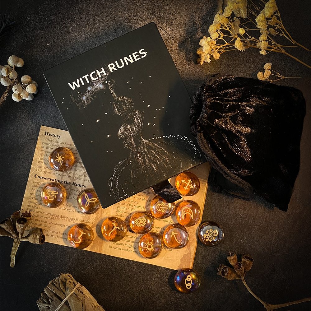 Witch runes set with book and amber class stones on a dark surface
