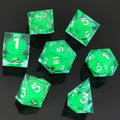 Set of green polyhedral Glow-in-the-Dark Liquid Core dice with white numbers on a black background
