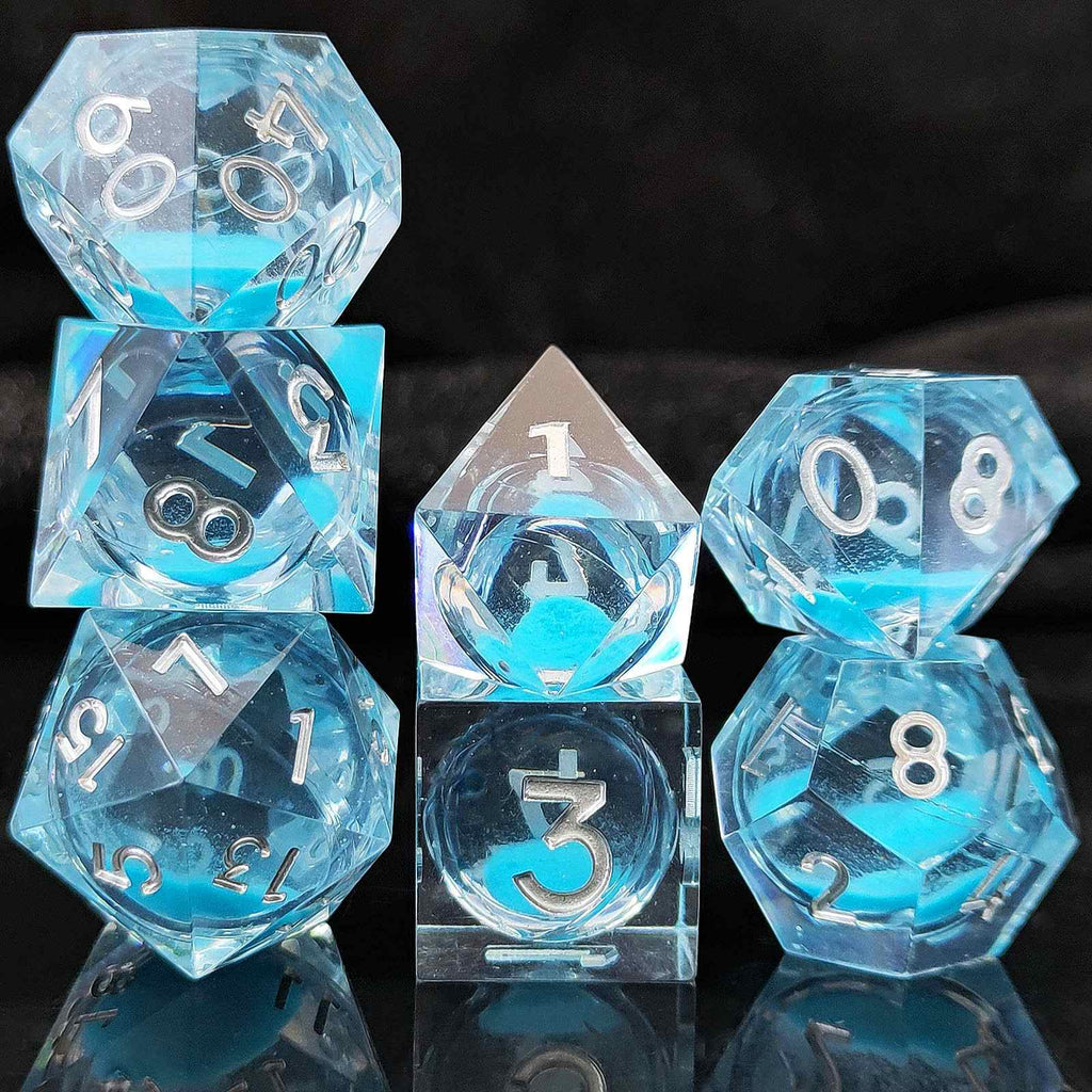 Set of blue and clear polyhedral Glow-in-the-Dark Liquid Core dice on a black background