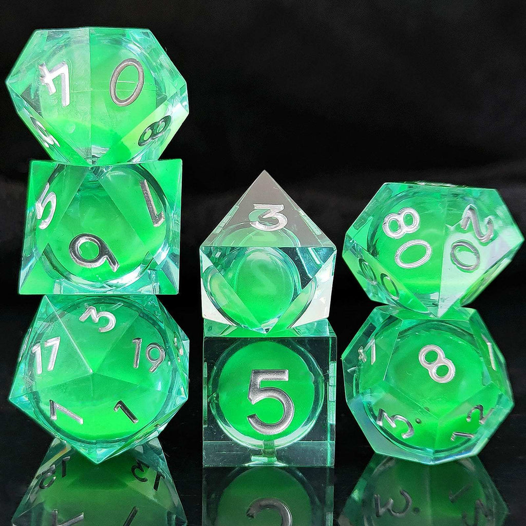 Set of green polyhedral Glow-in-the-Dark Liquid Core dice with clear faces on a black background