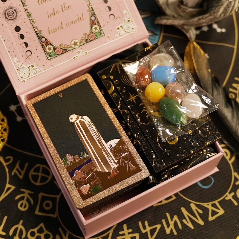 Pink box with foil tarot cards and colorful Chakra crystals on a mystical tablecloth