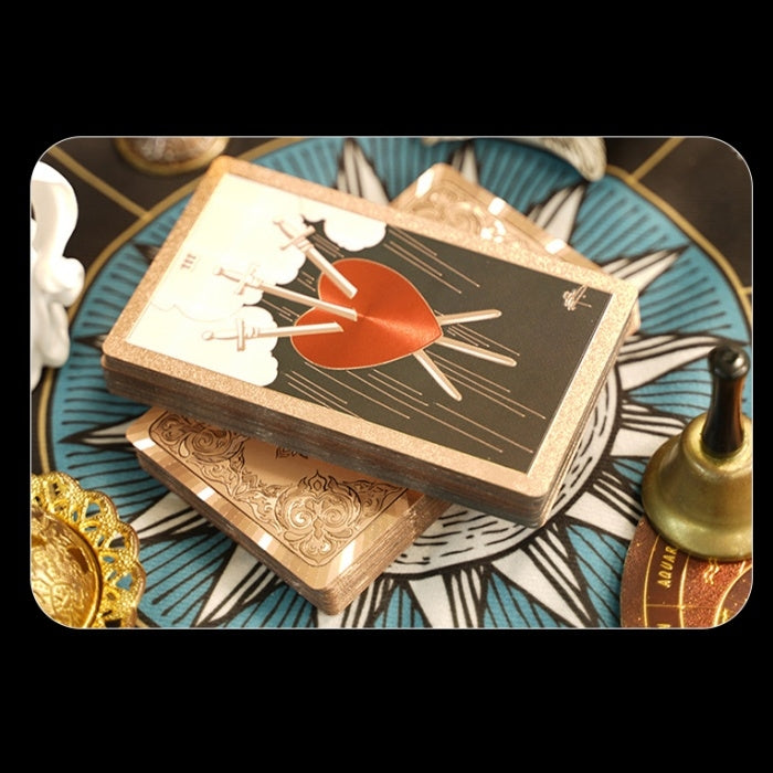 gold foil tarot cards with a heart design on a patterned surface