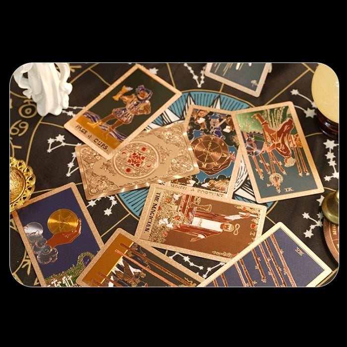 Collection of foil tarot cards on a dark surface with star and moon symbols.