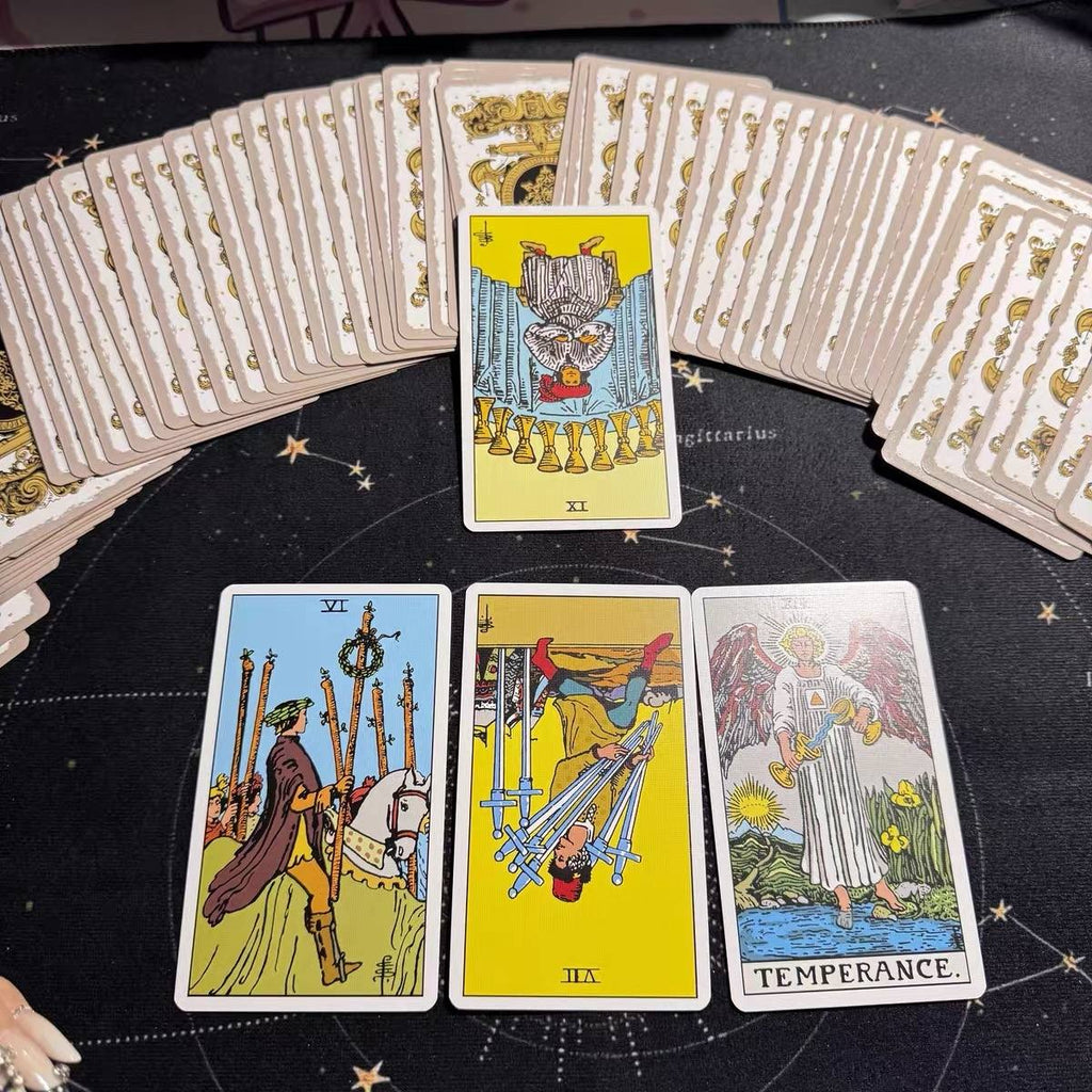 Four tarot cards on a black surface with star patterns, surrounded by additional tarot cards.