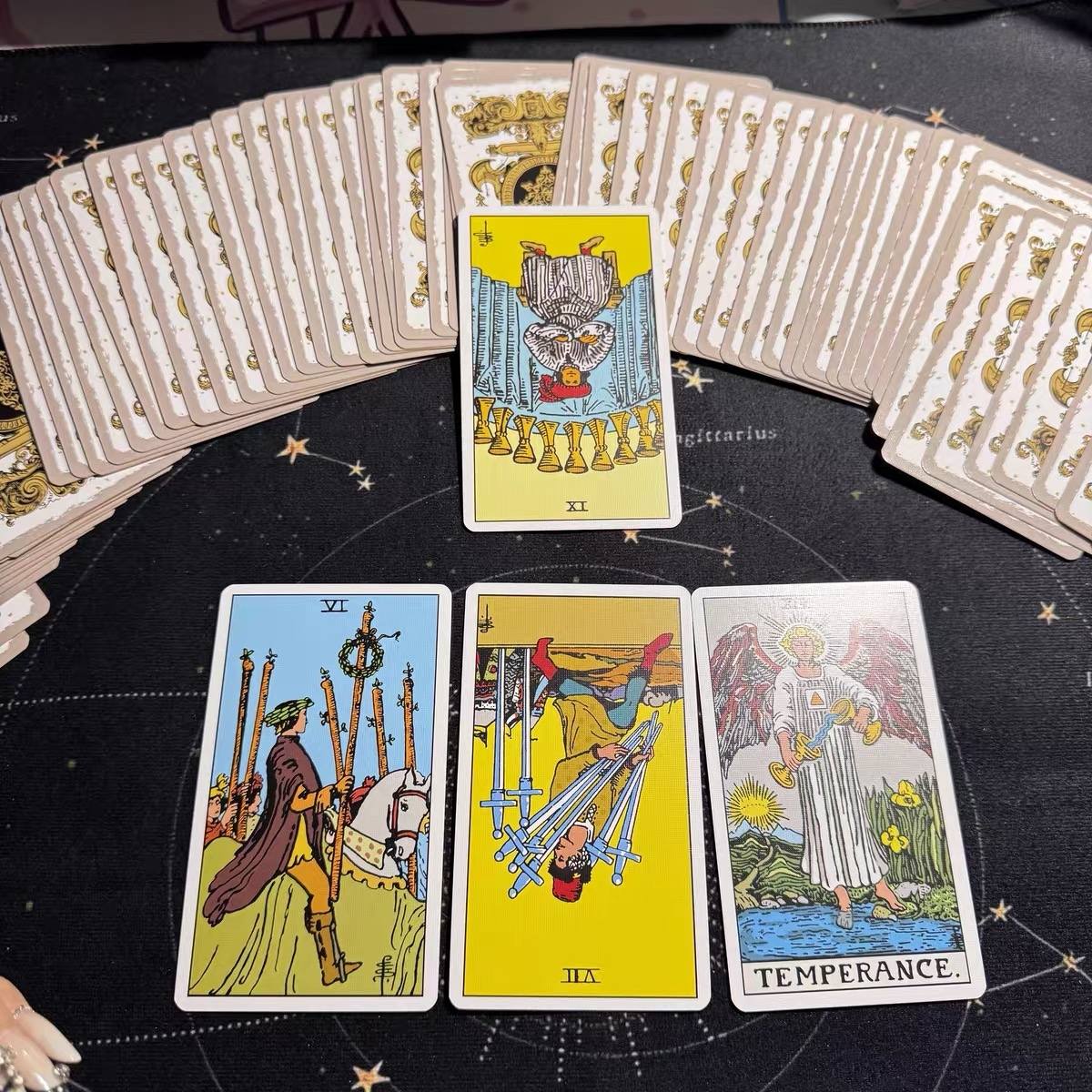 Four tarot cards on a black surface with star patterns, surrounded by additional tarot cards.