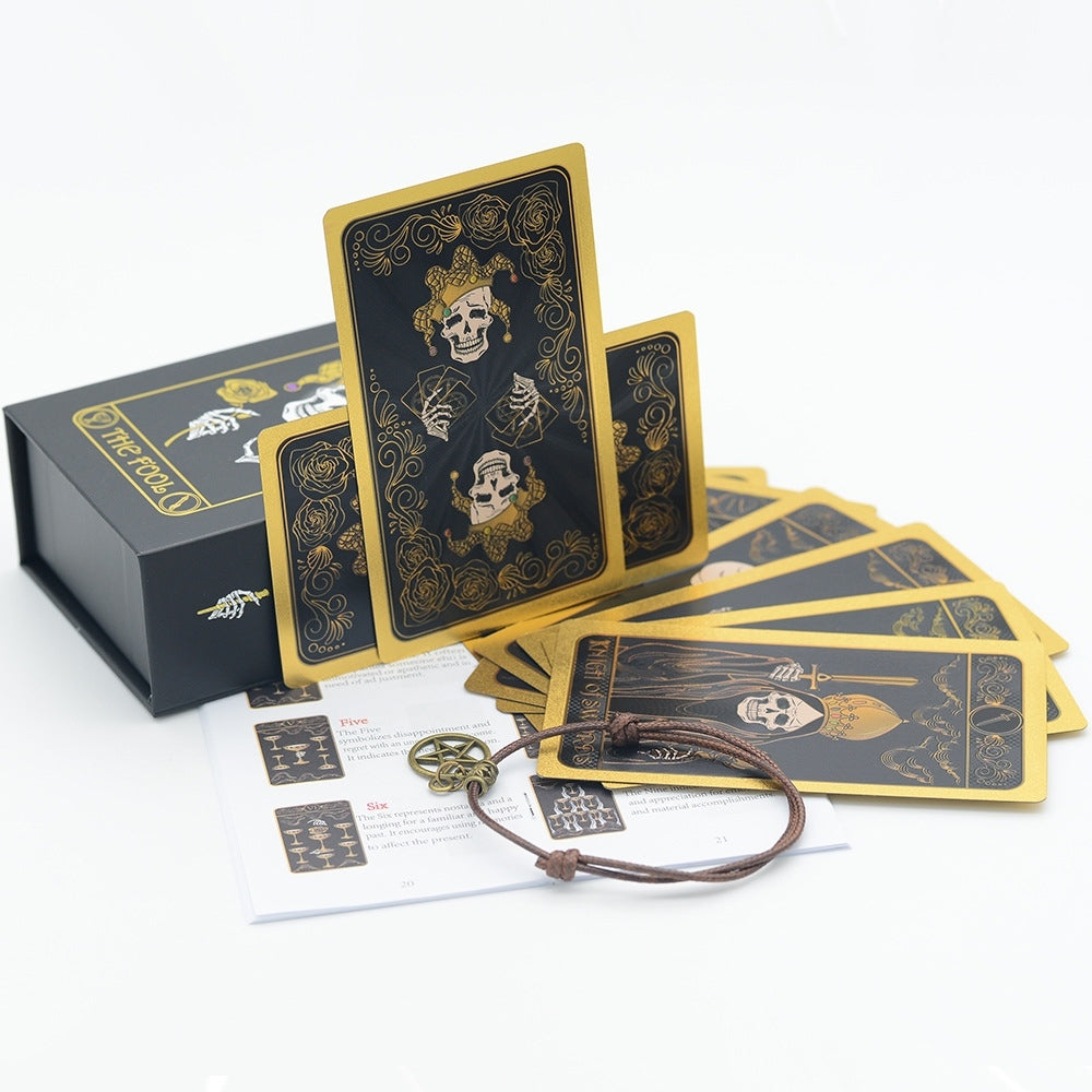 Black and gold Gothic Skull Black Gold Foil tarot cards with skull design, box, and paper on a white background