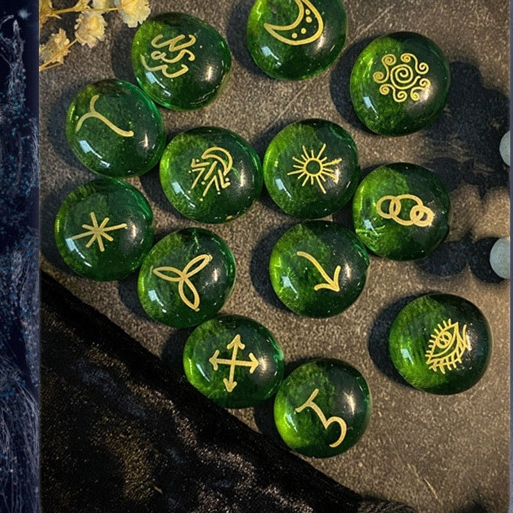 Green witch rune stones with gold symbols on a textured surface