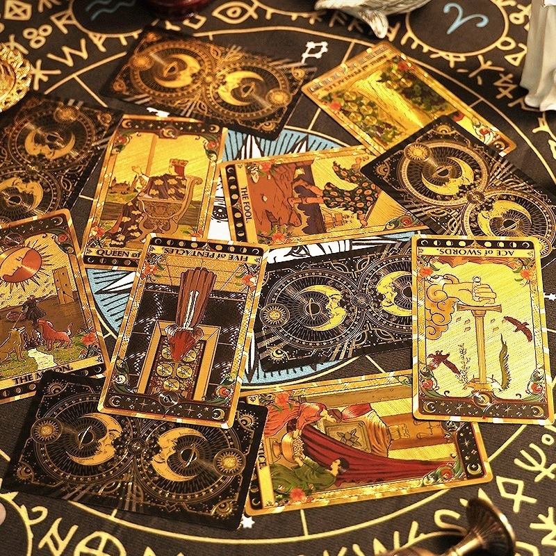 Collection of premium gold foil tarot cards on a black and gold tarot board with astrological symbols.