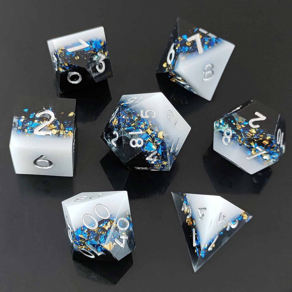 Set of liquid core resin dice with blue and gold embellishments on a black background