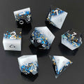 Set of liquid core resin dice with blue and gold embellishments on a black background