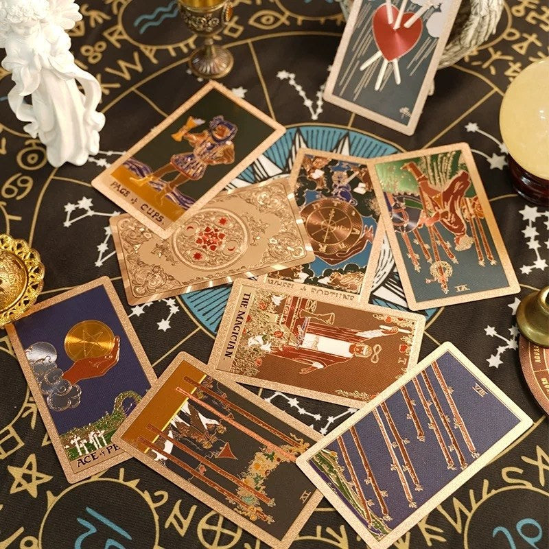 Collection of tarot cards on a black tablecloth with astrological symbols