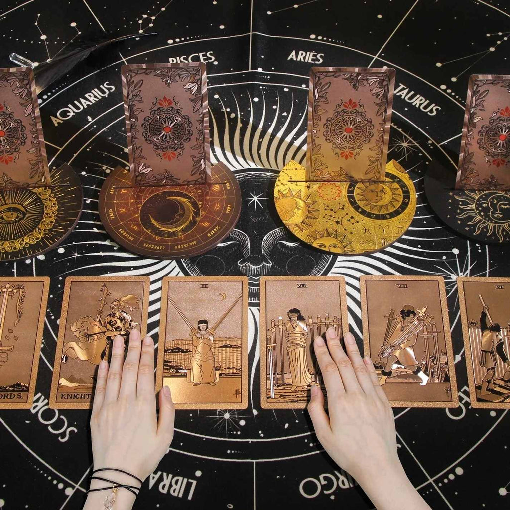 Tarot cards with astrological signs and hands on a starry background
