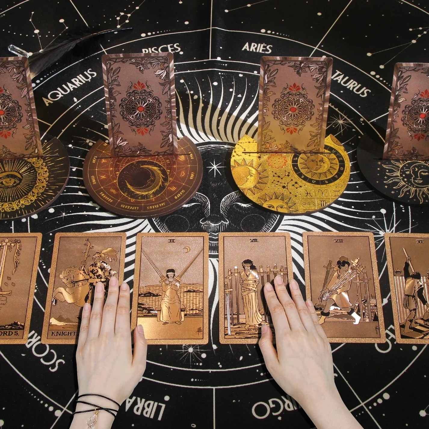 Tarot cards with astrological signs and hands on a starry background