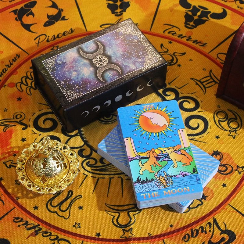 Tarot cards with a decorative box on a zodiac-themed surface
