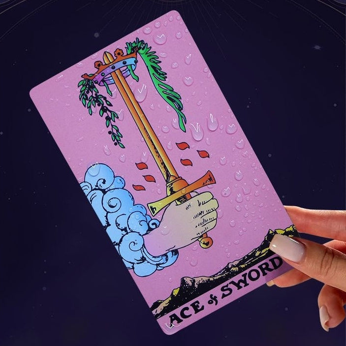 Hand holding a tarot card titled 'Ace of Swords' with a pink background