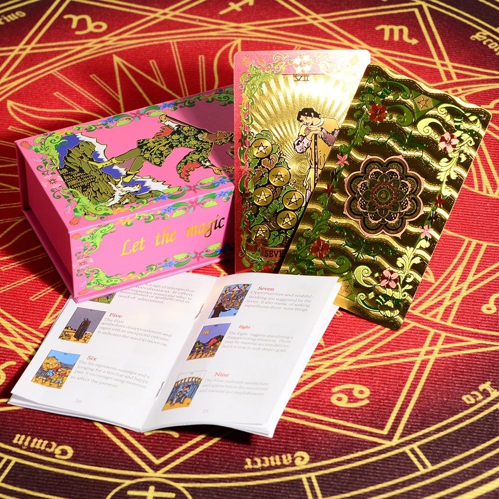Pink & Gold Foil Mandala tarot card set with a pink box and open book on a red astrological design background.