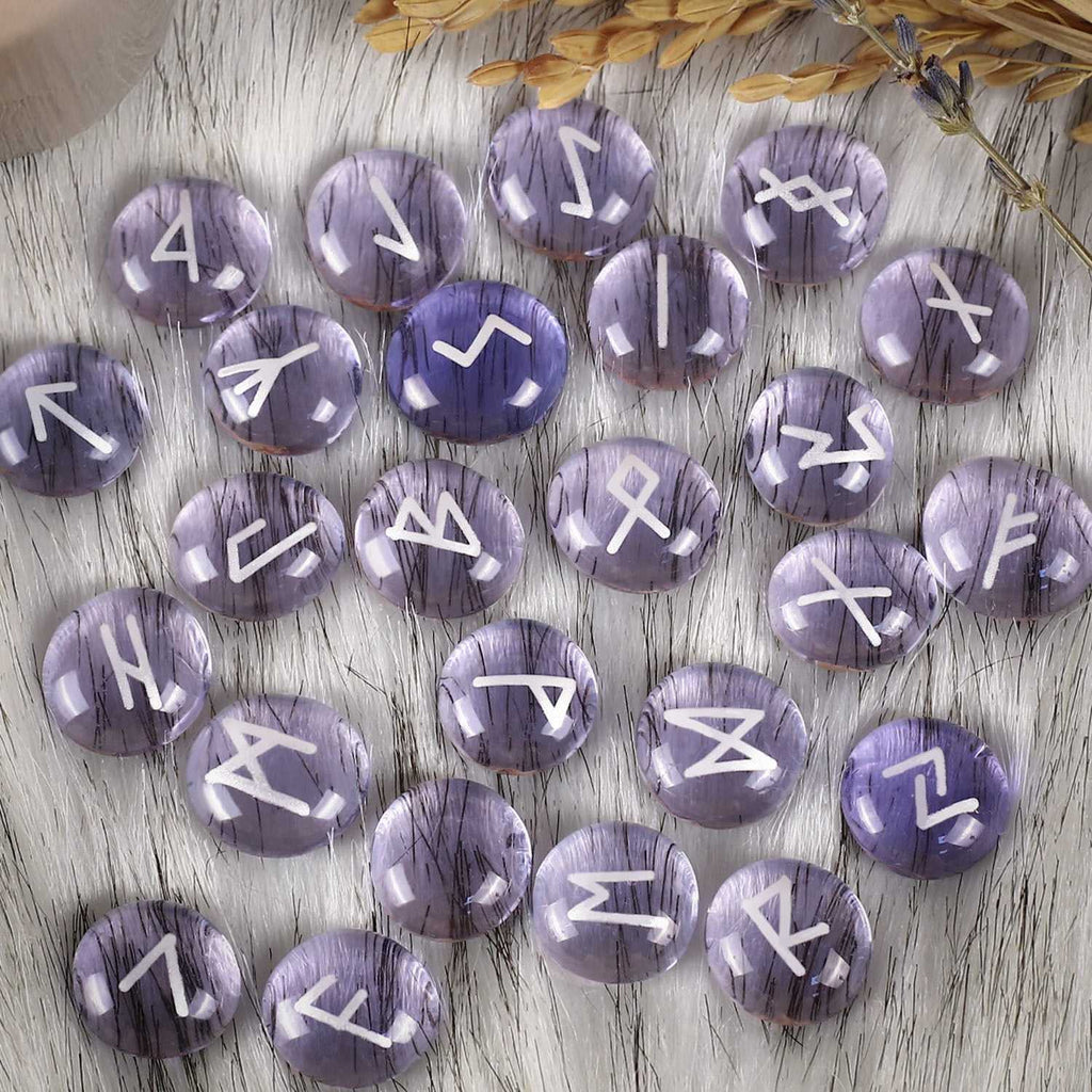 Purple stones with white symbols on a wooden surface