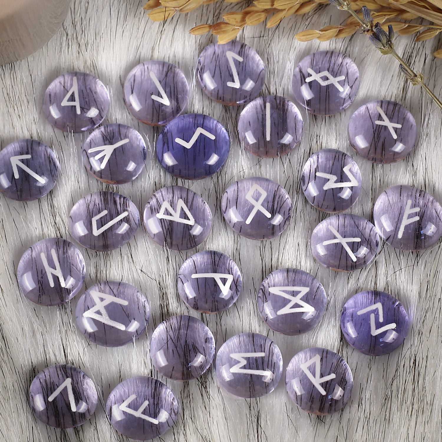 Purple stones with white symbols on a wooden surface
