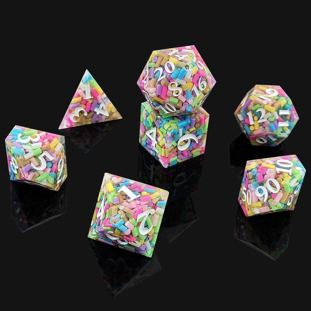 Set of colorful polyhedral resin dice with letter and number patterns on a black background