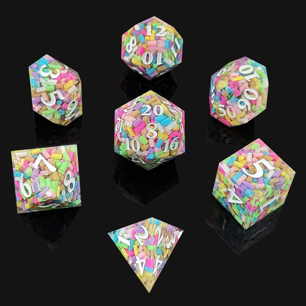 Set of colorful polyhedral resin dice with letter and number embossing on a black background