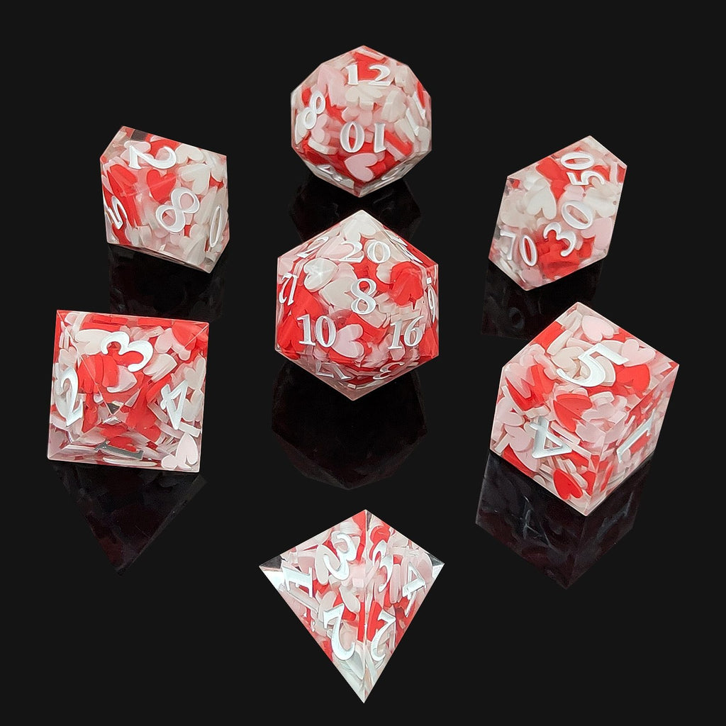 Set of red and clear Sharp Edge Polyhedral resin dice on a black background