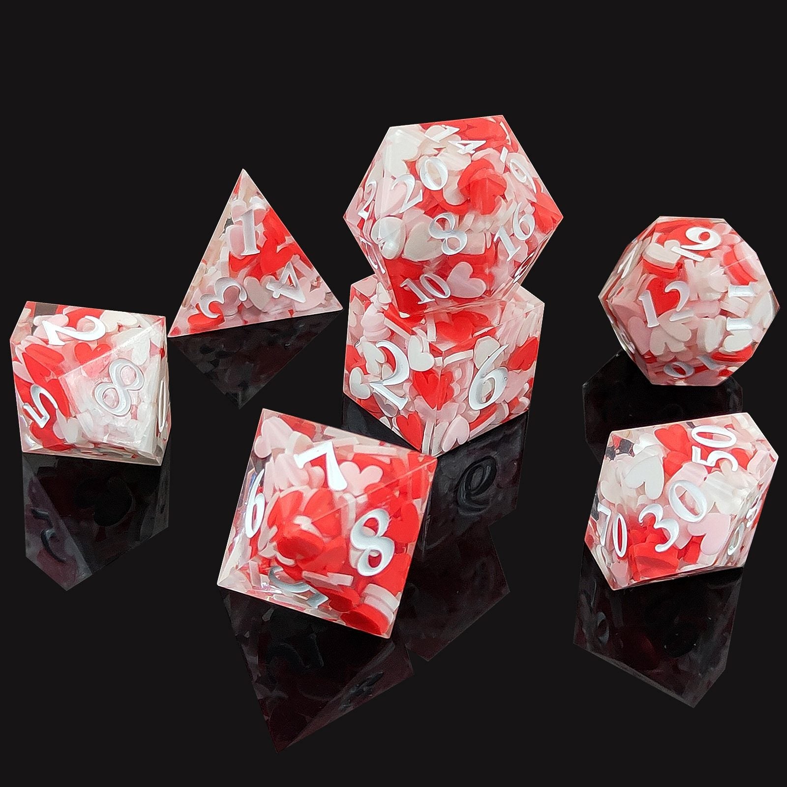 Set of red and white Sharp Edge Polyhedral resin dice on a black background